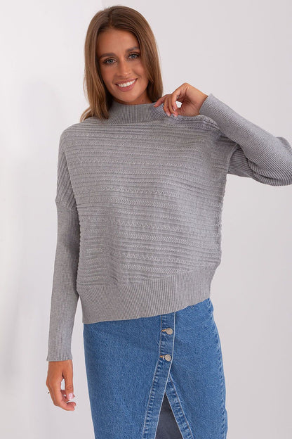 Stylishly paired women's variegated knit sweater with jeans, perfect for a casual yet sophisticated look.