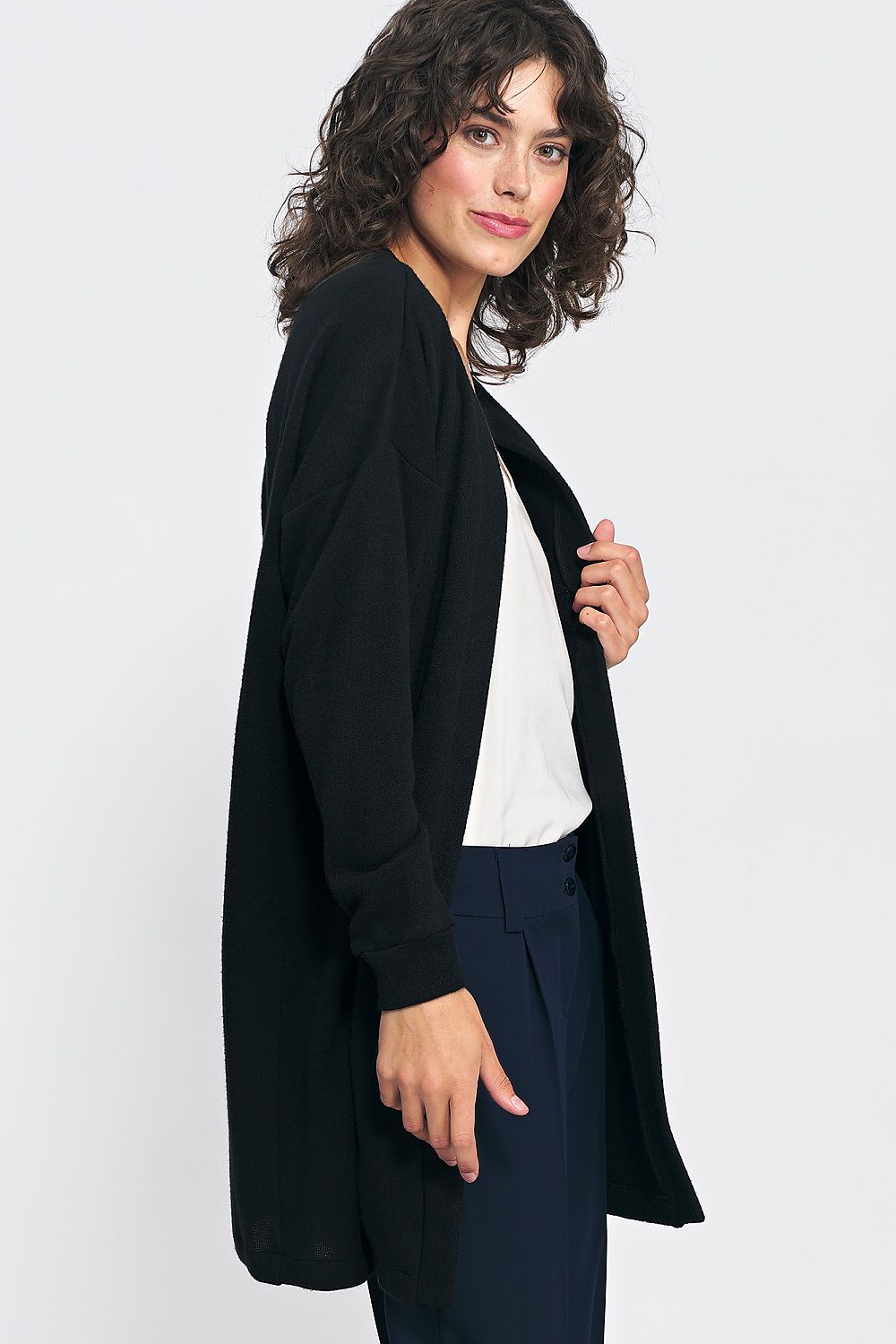 Close-up of the luxurious soft knit fabric of the unbuttoned black cardigan by Nife, ideal for enhancing chic outfits.