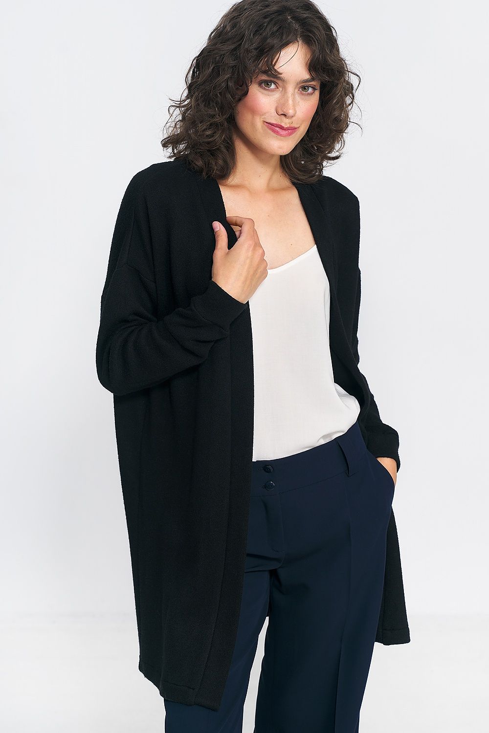Fashionable model wearing the unbuttoned black cardigan by Nife, showcasing versatile styling options for weekend looks.