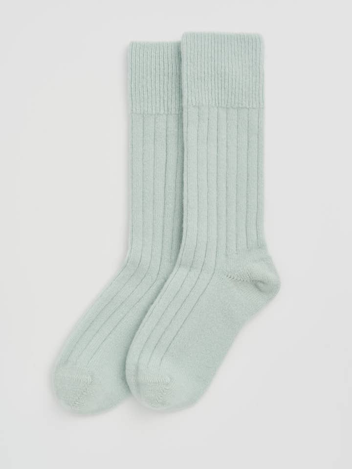 Luxury Merino bed socks folded neatly, revealing their eco-friendly materials, including recycled polyamide.