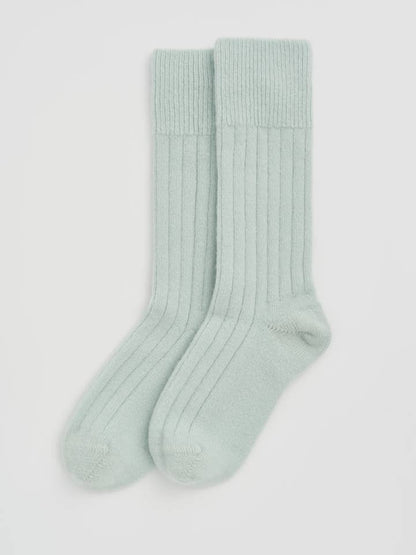 Luxury Merino bed socks folded neatly, revealing their eco-friendly materials, including recycled polyamide.