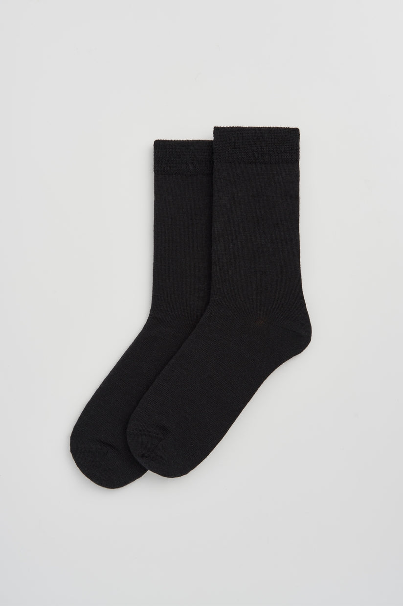 Stylish Merino wool calf-length socks in a sophisticated setting, highlighting their versatility and one-size-fits-most design.