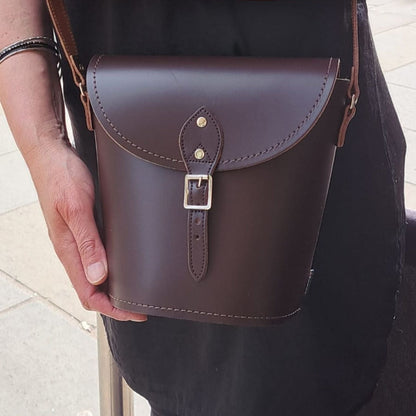 Compact yet spacious luxury barrel bag, perfect for everyday essentials, highlighting traditional artisan craftsmanship.