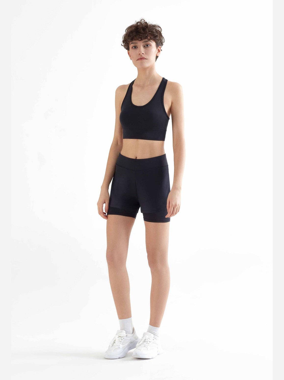 Luxurious eco-friendly women's sports bra made from 94% recycled polyester featuring a figure-hugging cut and wide double-layered straps, perfect for activewear and everyday comfort.