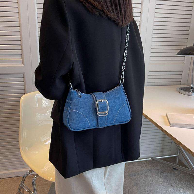 Stylish denim shoulder bag adorned with attractive buckle details, highlighting luxury style for modern women.