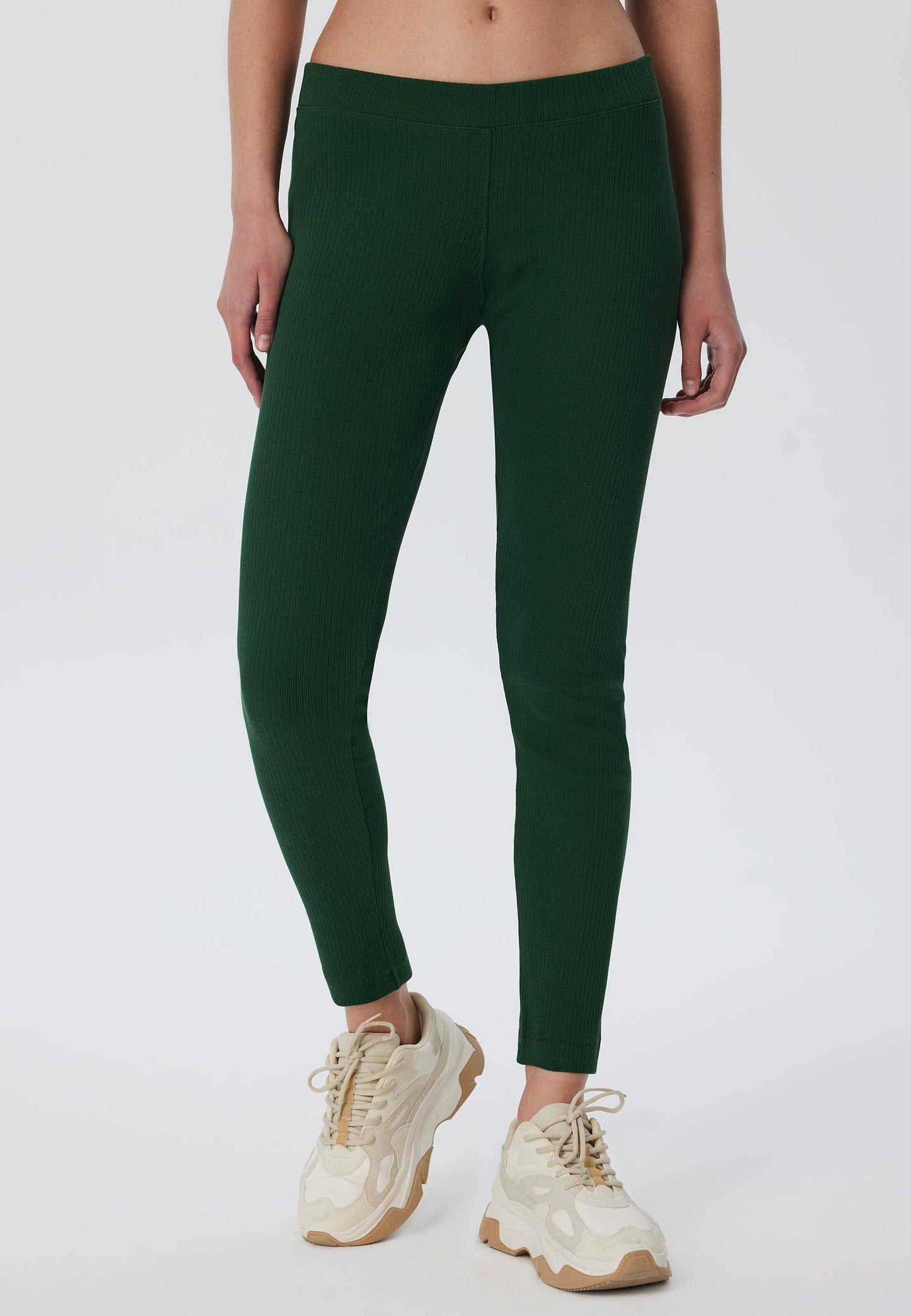 Luxury organic cotton ribbed leggings for women in elegant black, designed for a snug fit with a soft elasticated waist.