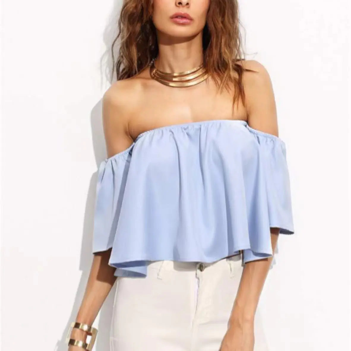 Elegant blue chiffon blouse with off-shoulder design, styled with a statement necklace and white jeans.