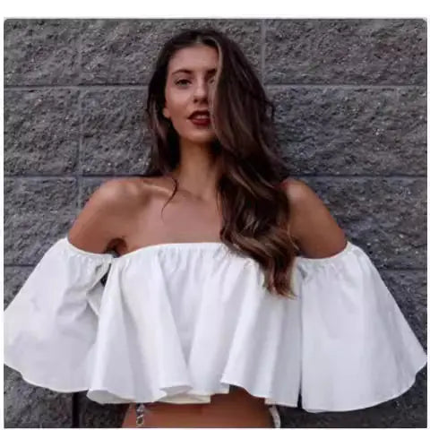 Chic white chiffon blouse displayed on a model with an off-shoulder design, radiating elegance in a casual outdoor scene.