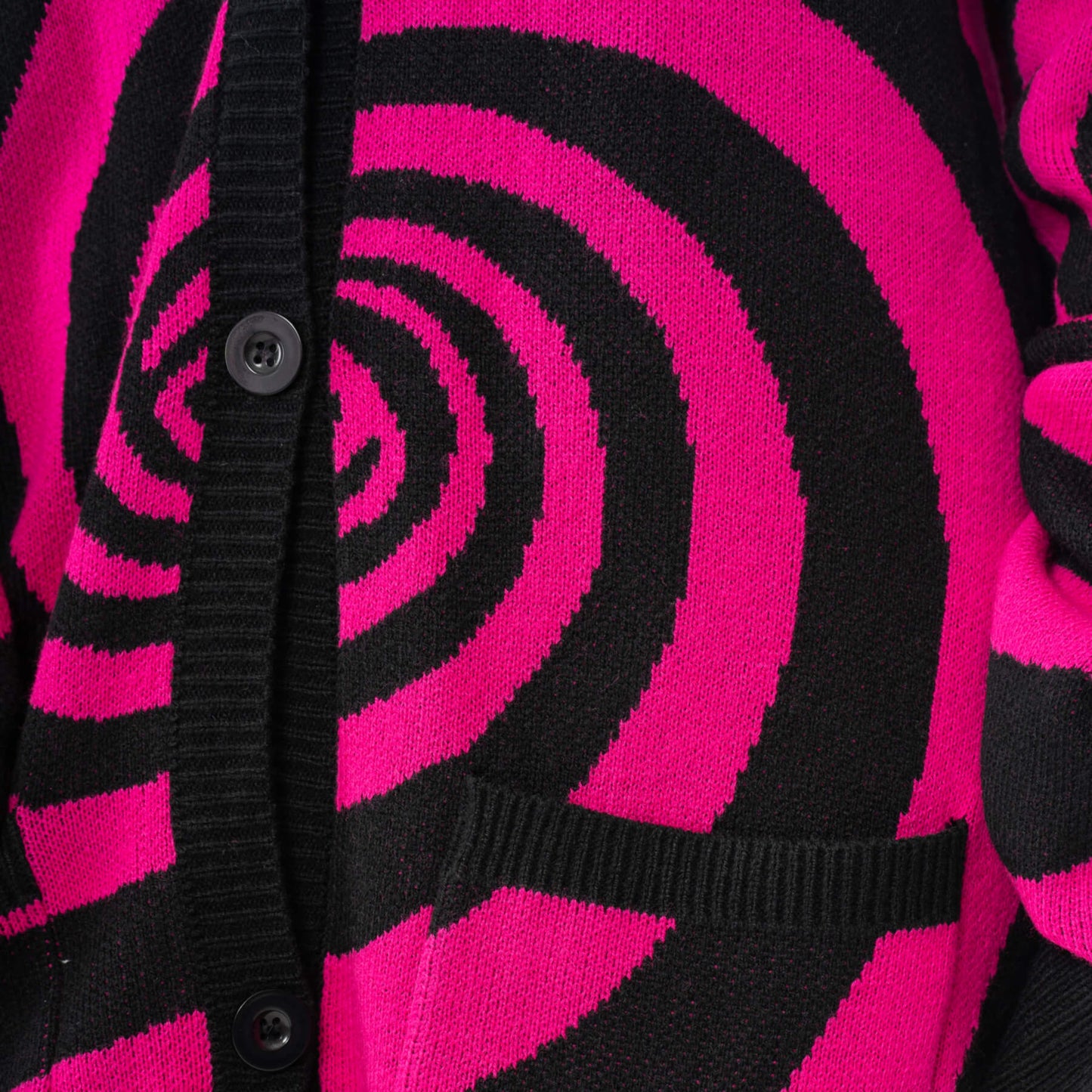 Vixxsin oversized black and hot pink Hypno cardigan showcasing a bold swirl knit design, perfect for making a fashion statement.