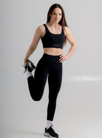 Incl.usiveinc Active Black Sports Bra paired with high waist leggings, demonstrating an elegant and functional workout ensemble.