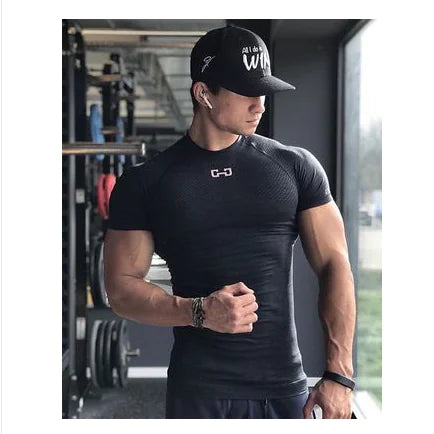 A toned male athlete wearing a premium black compression t-shirt in a contemporary gym, reflecting luxury fitness wear that combines style and functionality.