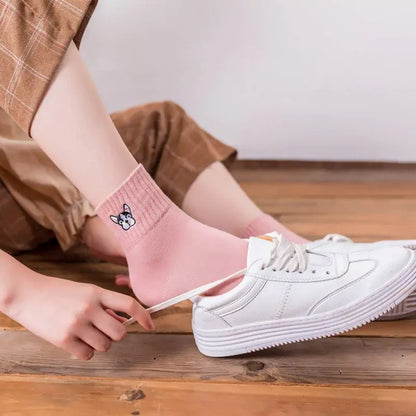 A pair of pink Cozy Women's Cotton French Bulldog Embroidered Socks, styled with white sneakers, perfect for casual wear and dog enthusiasts.
