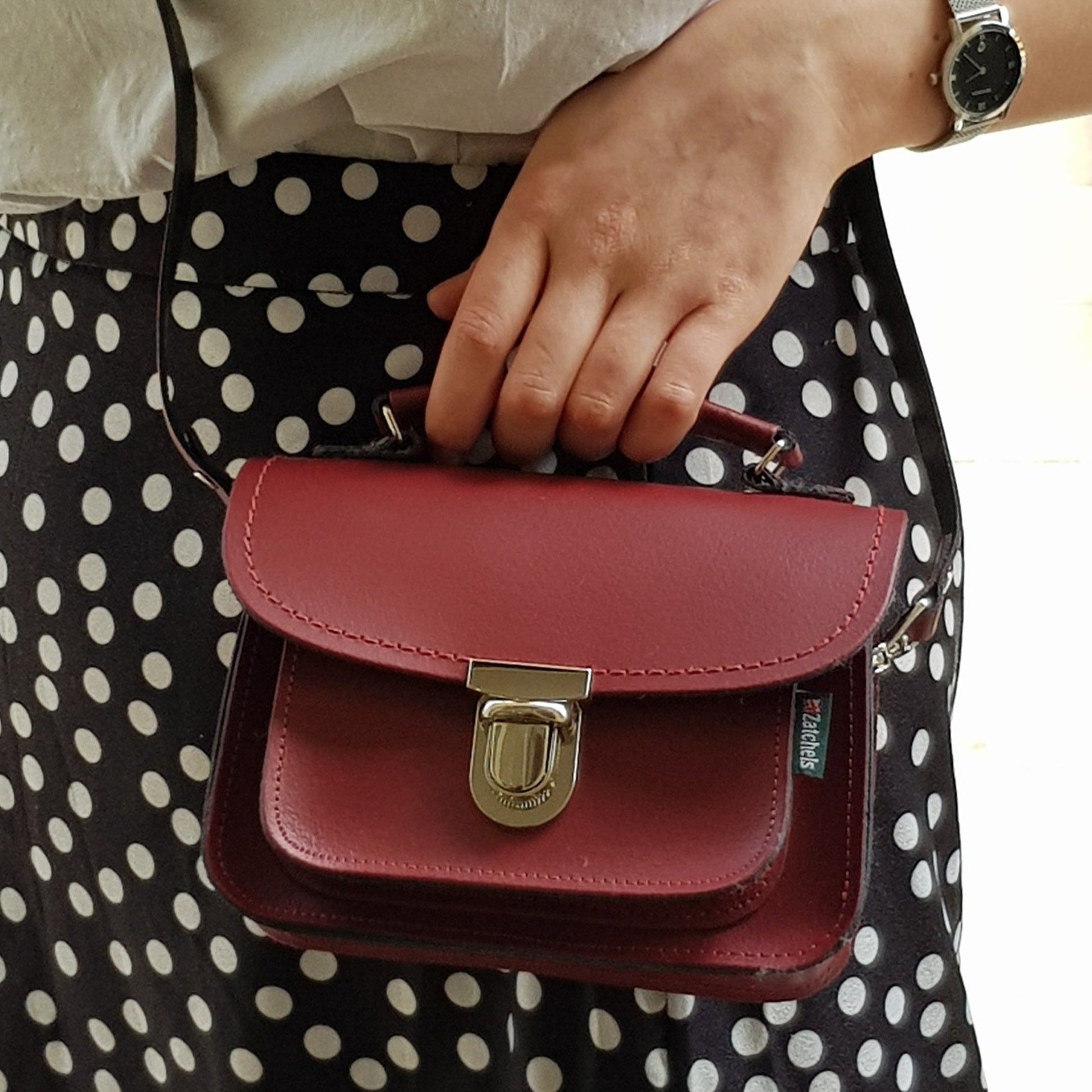 Luna Handmade Oxblood Red Leather Bag styled as a clutch, highlighting its sophisticated top handle and contemporary flair.
