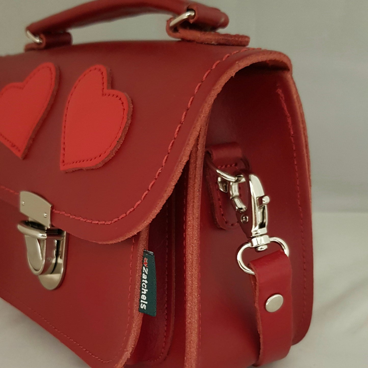 Luna Handmade Leather Crossbody Bag in vibrant red with contrasting love hearts, showcasing elegant design and premium craftsmanship by Zatchels, perfect for stylish outings.