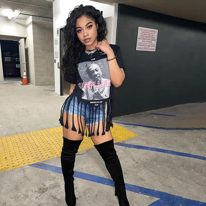 Women's ODB Graphic Print Tassel Tee with Stretchy Fabric for Chic Street Style, showcasing a model wearing the stylish tee with playful tassels, paired with denim shorts and knee-high boots, exuding a confident urban vibe.