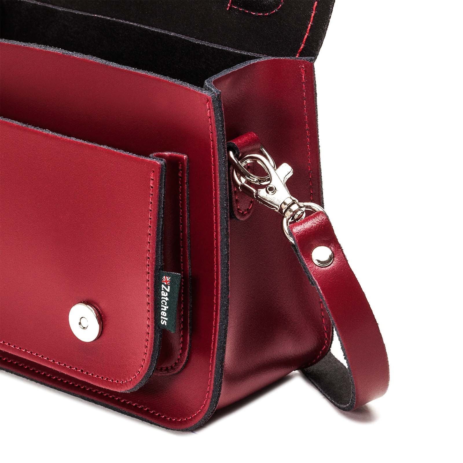 Versatile oxblood leather micro satchel with adjustable and detachable strap, elegantly transforming from a functional satchel to a chic clutch.