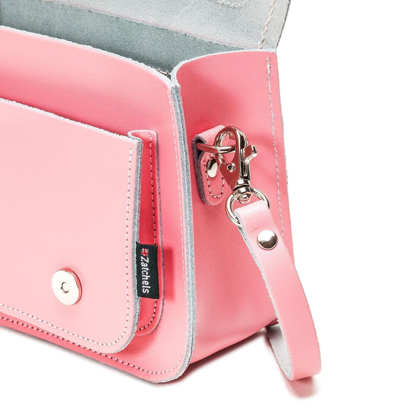 Pastel pink leather micro satchel styled as a chic clutch, featuring a detachable strap for versatile wear and functionality.