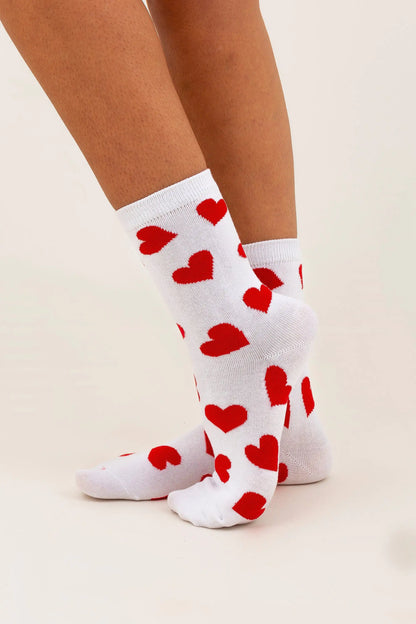 Charming Women's White Socks with Elegant Red Hearts for Stylish Comfort and Fashionable Appeal, displayed as a model's feet are elegantly styled, showcasing the heart design.