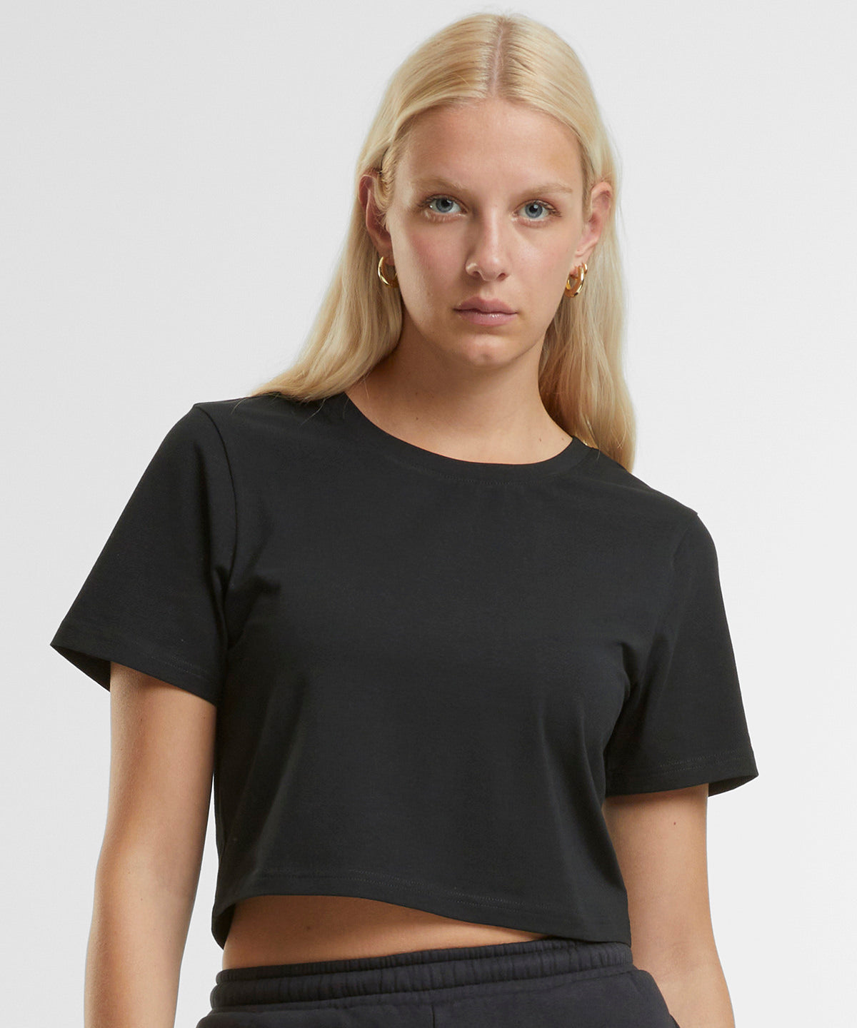 Detail of the Organic Cotton Stretch Cropped T-Shirt featuring short sleeves, perfect for layering under jackets in a sophisticated summer look.