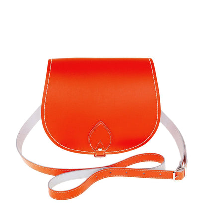 Luxurious handmade orange leather saddle bag with adjustable crossbody strap and oversized flap, showcasing traditional craftsmanship and modern style, ideal for daily use and available in two sizes.