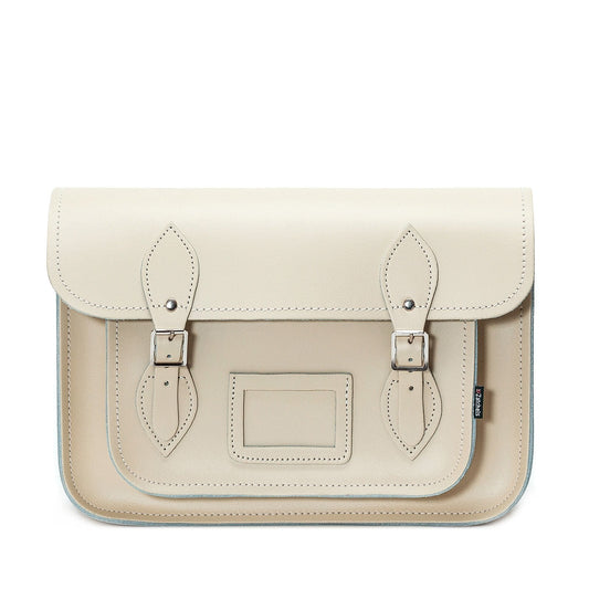 Handcrafted pastel cream leather satchel with adjustable cross-body strap, showcasing luxurious craftsmanship and elegant design.