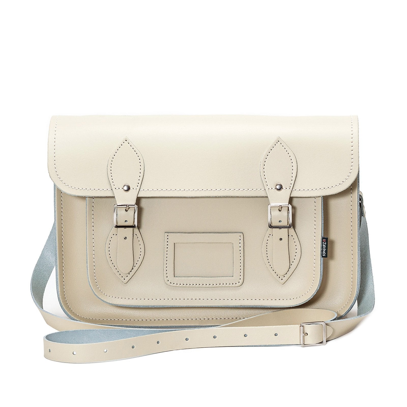 Close-up of the luxurious pastel cream leather texture and matching cable stitching of the handcrafted satchel.