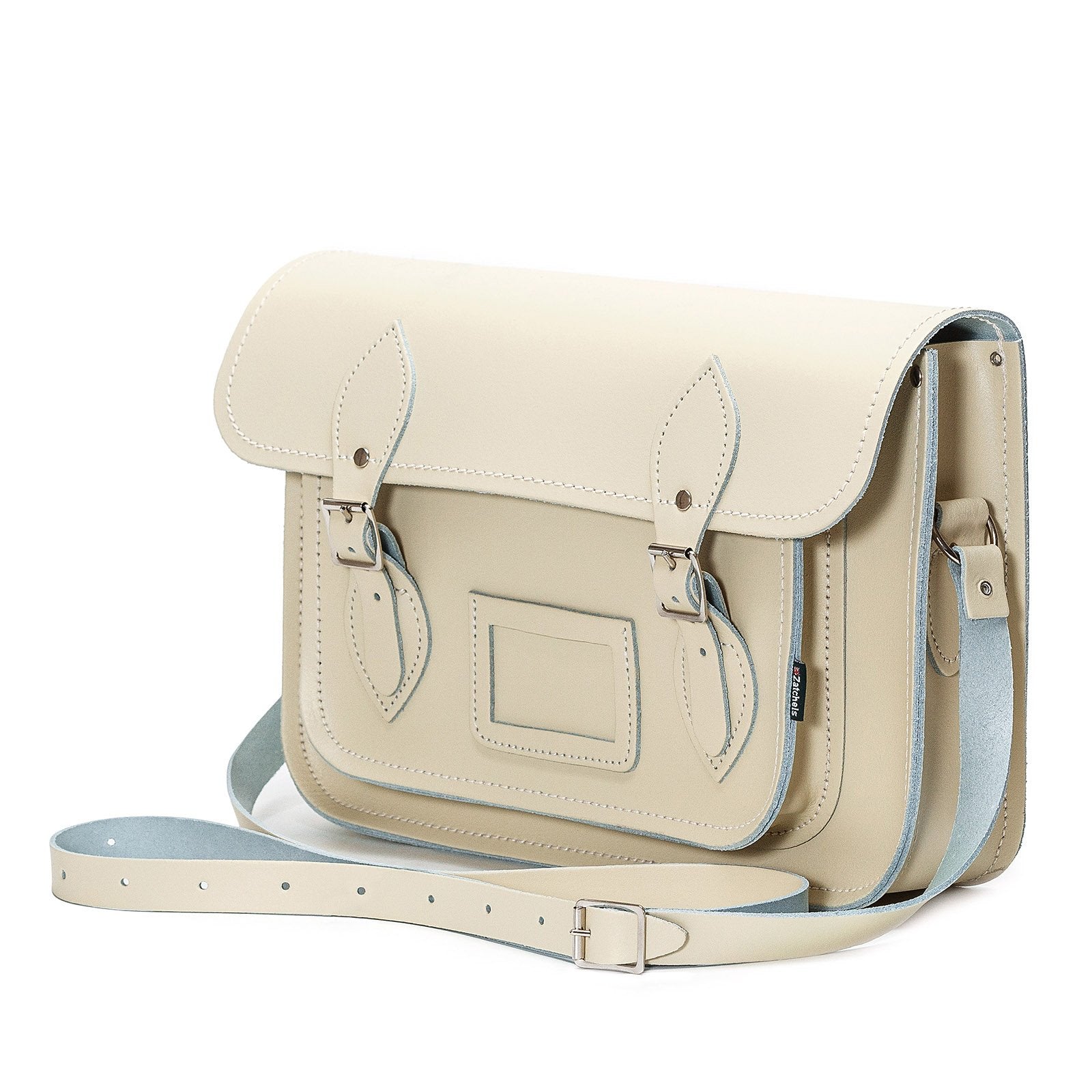 Stylish adjustable cross-body strap highlighted on the pastel cream leather satchel, perfect for versatile wear.