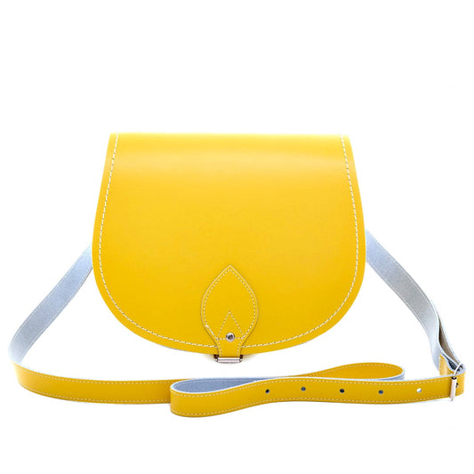Handmade pastel daffodil yellow leather saddle bag showcasing elegant design and craftsmanship by Zatchels, perfect for versatile styling.