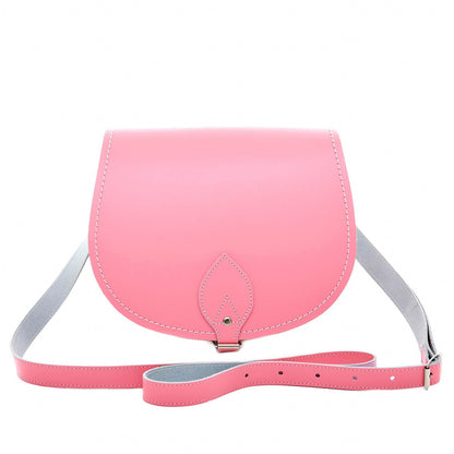 Elegant luxury handmade leather saddle bag in pastel pink with adjustable crossbody strap, showcasing exceptional craftsmanship and timeless design.