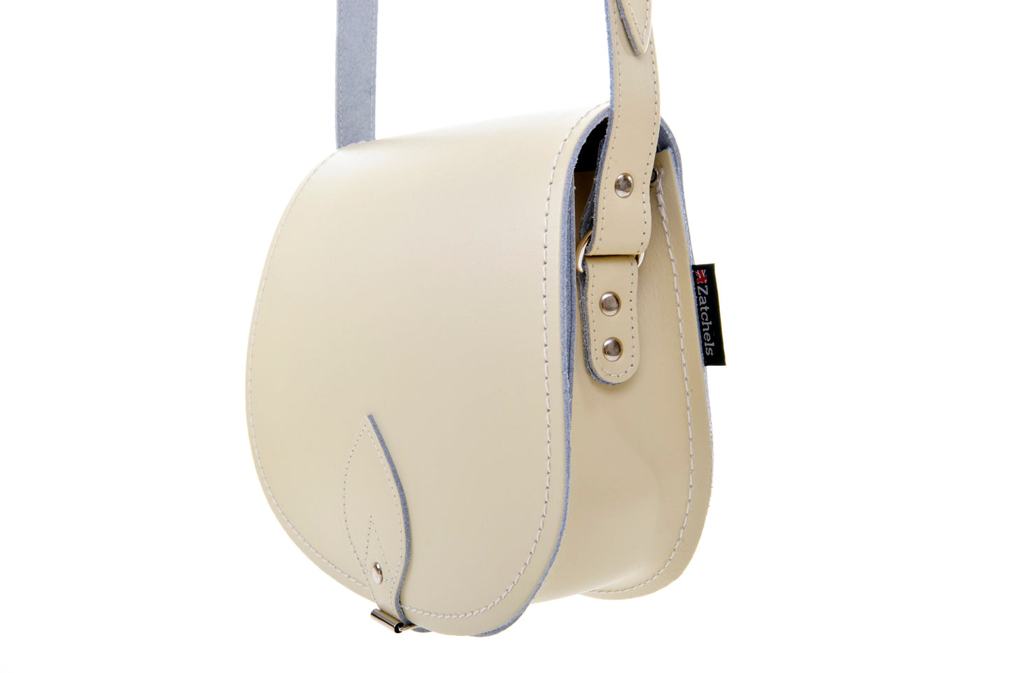 Interior view of a luxury pastel cream leather saddle bag showcasing spacious compartment and elegant craftsmanship, ideal for everyday use.