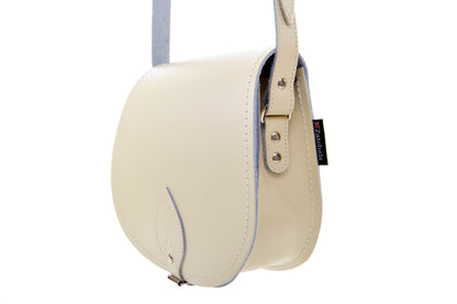 Interior view of a luxury pastel cream leather saddle bag showcasing spacious compartment and elegant craftsmanship, ideal for everyday use.