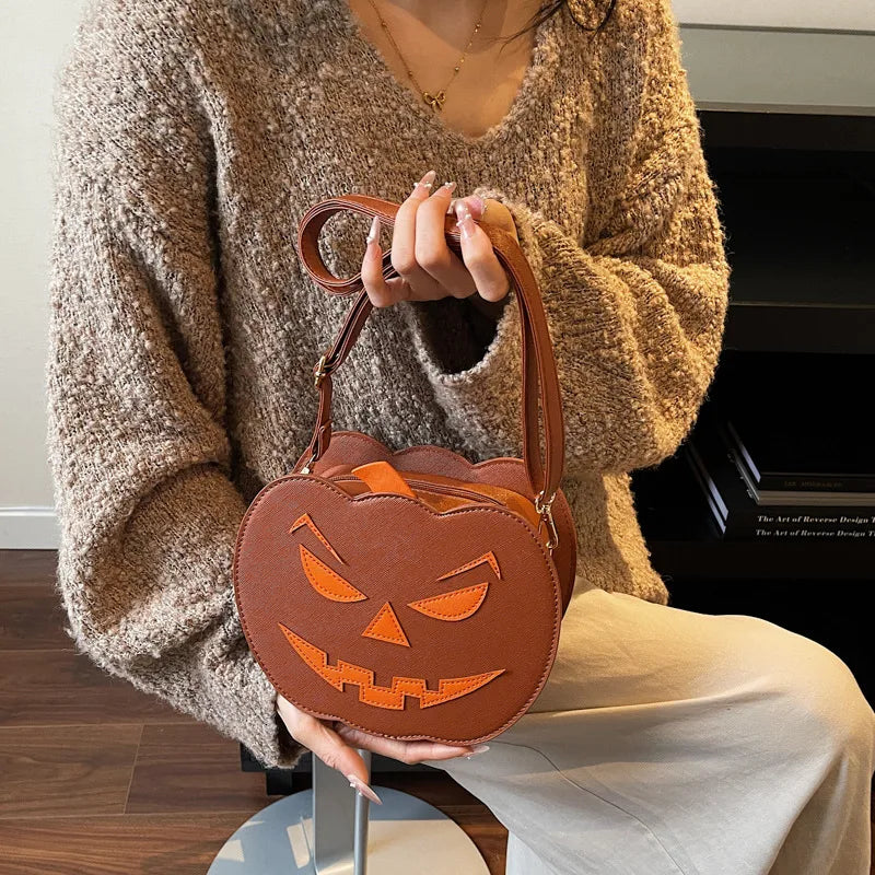 Opulent round crossbody handbag in a vibrant pumpkin shape, showcasing a secure zipper closure and affectionate heart motifs.