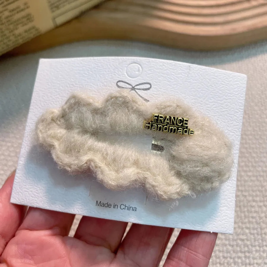 Fashionable women's high-end hair clip featuring plush lamb fur, a perfect blend of comfort and style.