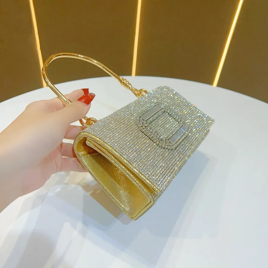 Stylish luxury evening clutch bag with a single shoulder strap, adorned with shimmering diamonds.