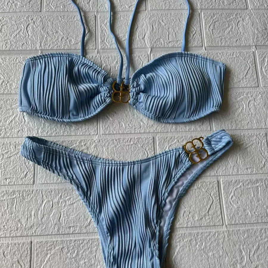 Trendy Women's Solid Colour Bikini Set laid out, perfect for luxury beach vacations and stylish summer appearances.