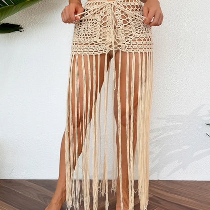 Luxurious women's sleeveless beach cover-up in breathable mesh, showcasing a stylish asymmetrical silhouette and refined tassel accents, ideal for chic summer lounging by the water.