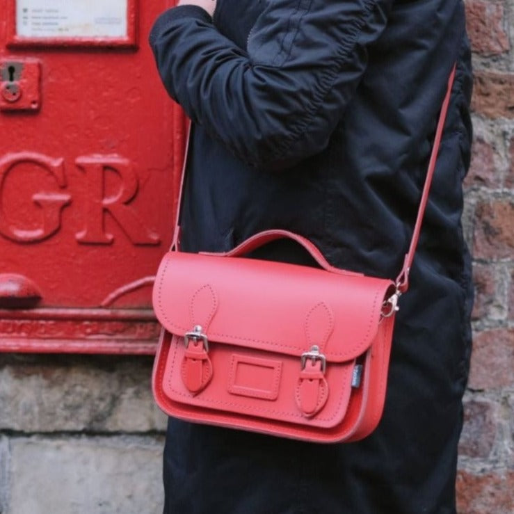 Stylish presentation of the Handmade Leather Midi Satchel in Pillar Box Red, highlighting its compact size, perfect for everyday essentials, accessorised for a chic look.