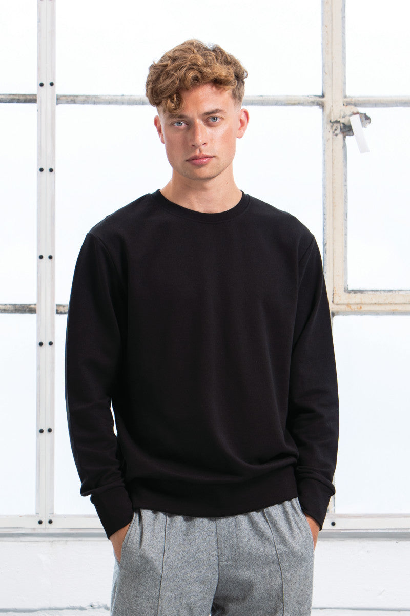 Close-up of premium quality organic cotton sweatshirt featuring ribbed cuffs and set-in sleeves for a refined fit.