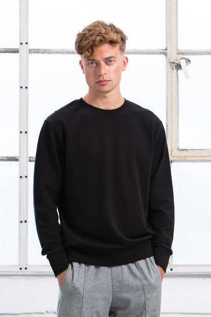 Close-up of premium quality organic cotton sweatshirt featuring ribbed cuffs and set-in sleeves for a refined fit.