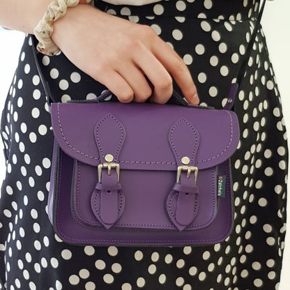 Close-up view of the stunning purple leather micro satchel showcasing exquisite stitching and nickel silver buckles, embodying luxury and style.