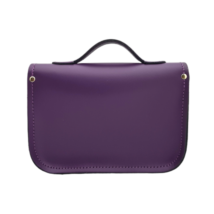 Versatile 9-inch purple leather satchel styled as a chic clutch, with an adjustable strap for shoulder or cross-body wear.