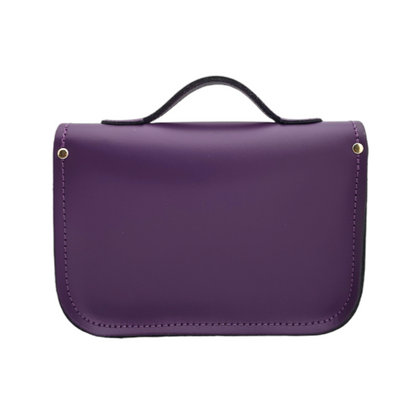 Versatile 9-inch purple leather satchel styled as a chic clutch, with an adjustable strap for shoulder or cross-body wear.