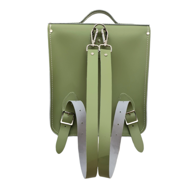 Versatile sage green leather city backpack styled as a crossbody bag, perfect for urban explorers and designed to carry laptops up to 13 inches.