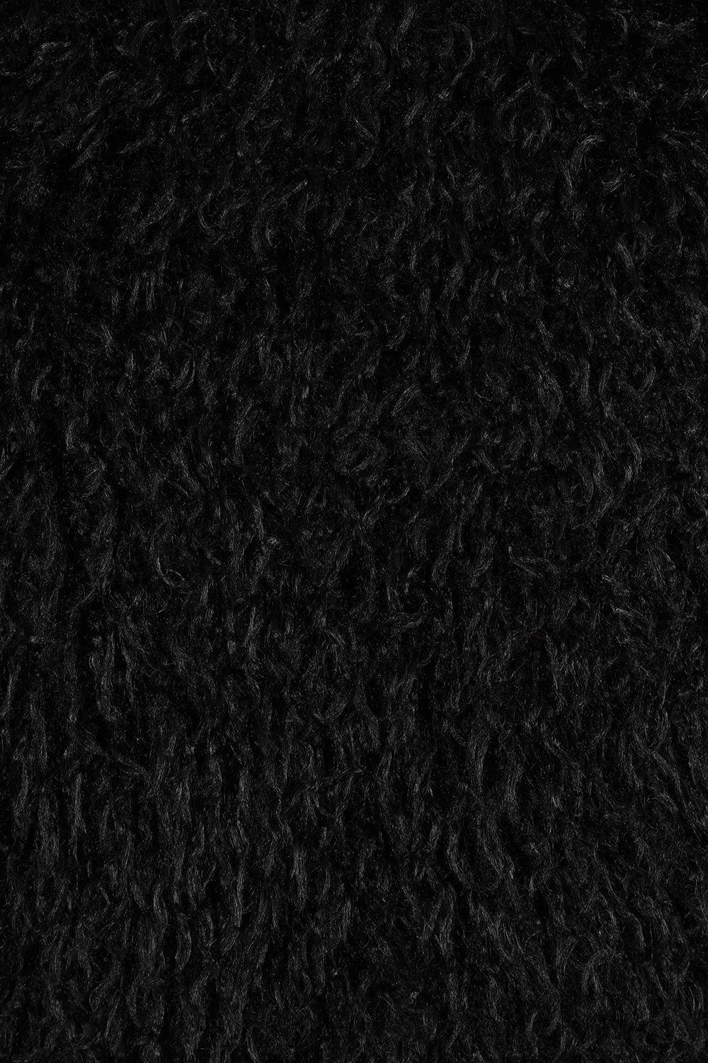 Close-up of the Banned Zafira Cropped Jacket's plush faux fur fabric, highlighting its rich black colour and intricate shaggy pattern, ideal for adding a rebellious edge to any outfit.