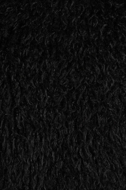 Close-up of the Banned Zafira Cropped Jacket's plush faux fur fabric, highlighting its rich black colour and intricate shaggy pattern, ideal for adding a rebellious edge to any outfit.