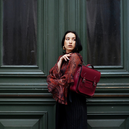 Close-up of exquisite stitching and silver nickel buckles on luxury handmade Oxblood leather backpack, highlighting sophisticated details.
