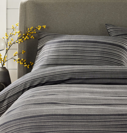 Full view of OLIVIA ROCCO’s luxurious stripe jacquard duvet cover set styled on a bed, beautifully illustrating the comfort and elegance it brings to any bedroom.
