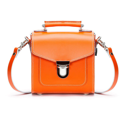 Handmade orange leather Sugarcube handbag showcasing elegant design and luxurious craftsmanship by Zatchels, featuring an adjustable strap for versatile styling.