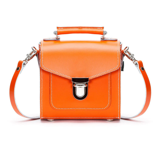 Handmade orange leather Sugarcube handbag showcasing elegant design and luxurious craftsmanship by Zatchels, featuring an adjustable strap for versatile styling.