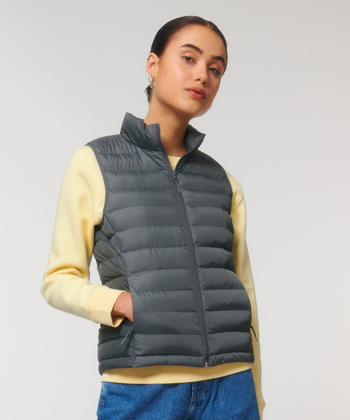 Elegant women's puffer bodywarmer, crafted from recycled materials, demonstrating a fusion of comfort and sophisticated style in an eco-friendly fashion piece.